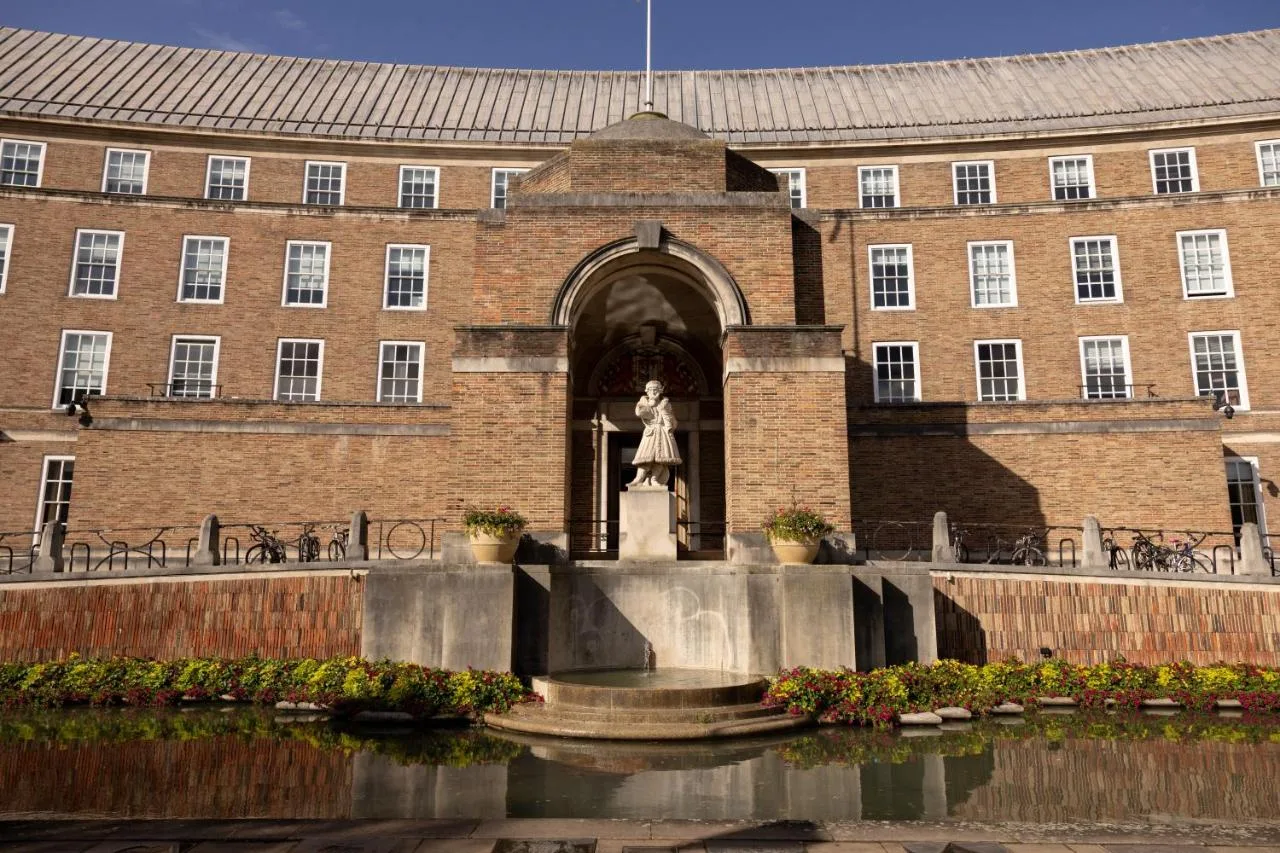 a statue in front of a brick building with a fountain at Moxy Bristol in Bristol