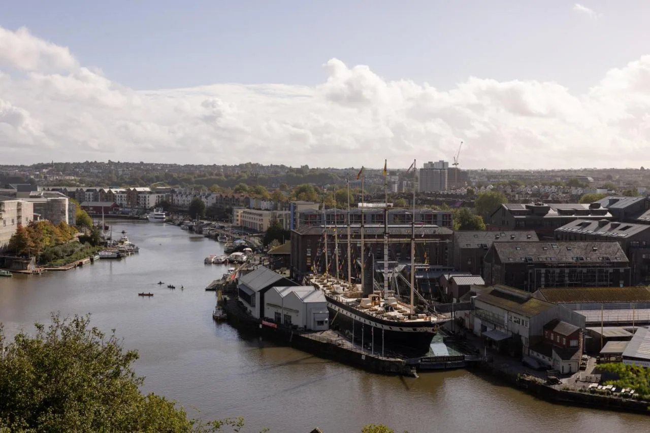 a river with boats docked in a city at Moxy Bristol in Bristol